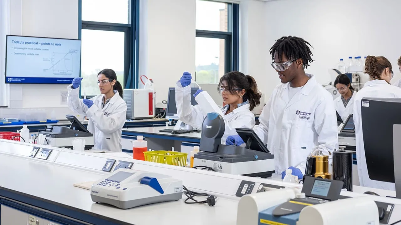 A group of students working in a chemistry lab and looking at data on computer screens