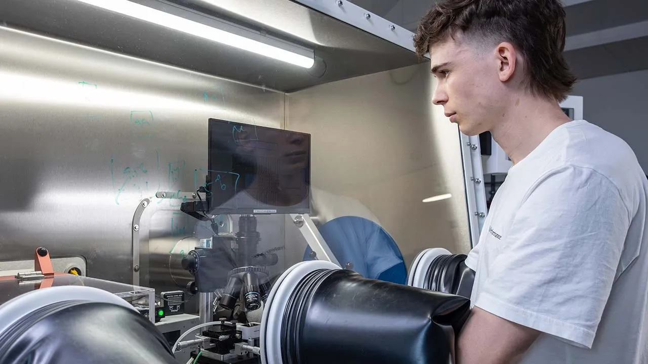 A student using microscopic equipment in a lab