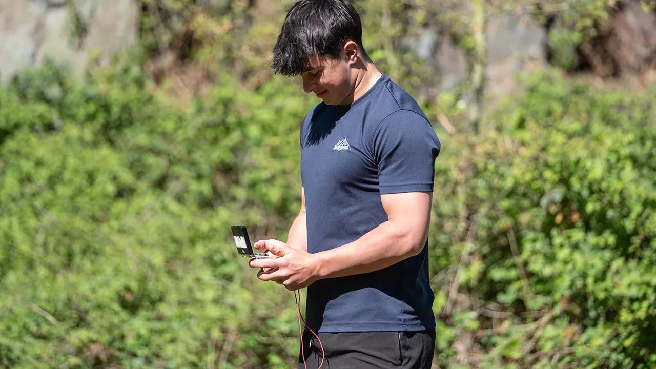 A geography student in the field holding a compass
