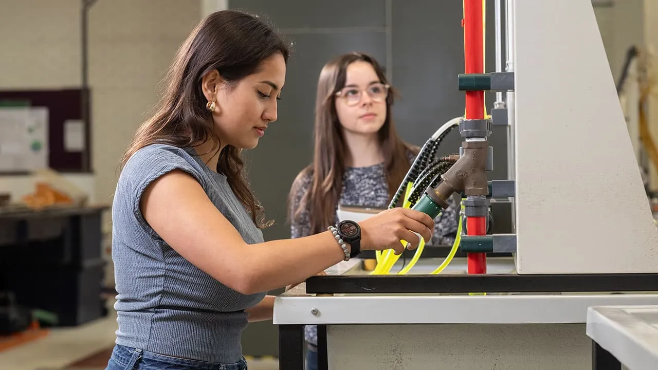 In a lab, two students are working together and using technical equipment