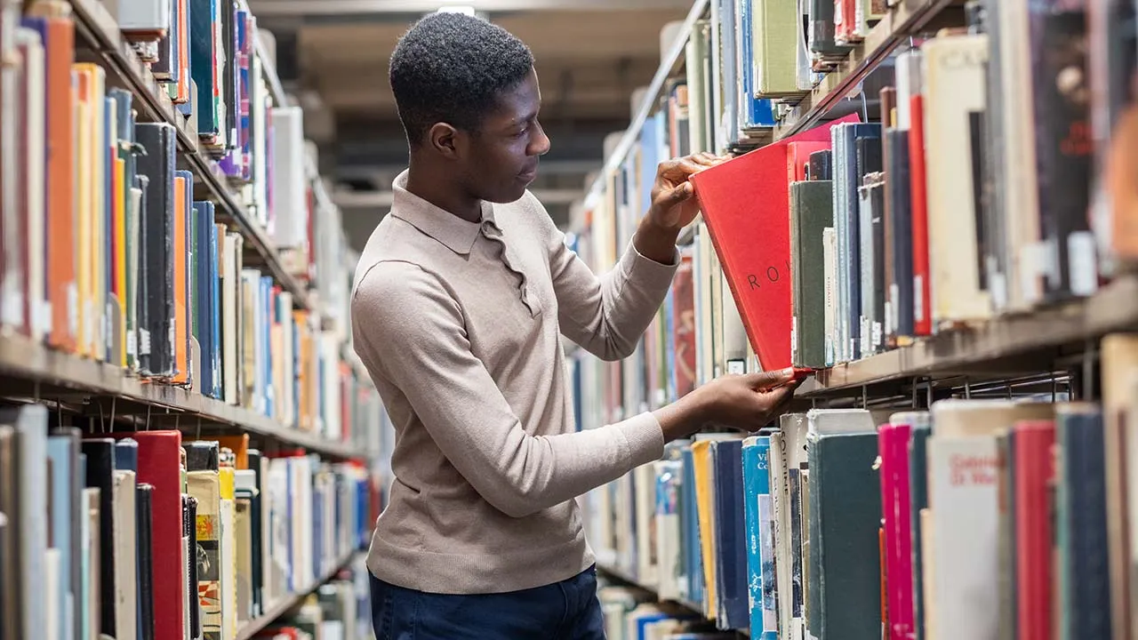 A student browsing books in the library