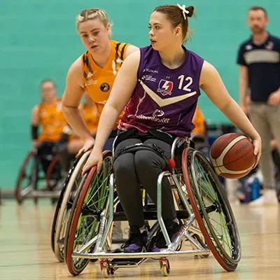 Ana Blease holding a basketball during a wheelchair basketball match