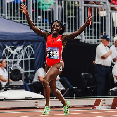 Daryl Neita on a running track holding a relay baton
