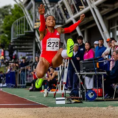 Jaz Sawyers in mid air during a long jump attempt