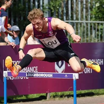 Josh Faulds jumping over a hurdle