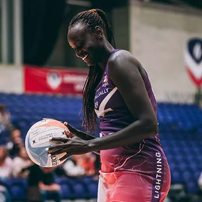 Mary Cholhok holding a netball on the court