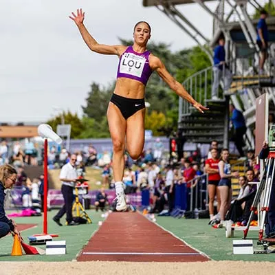 Molly Palmer in mid air during a long jump attempt
