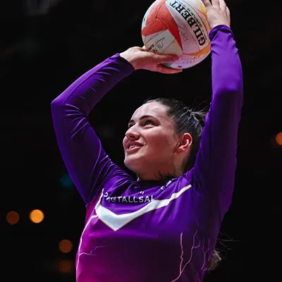 Niamh McCall holding a netball above her head