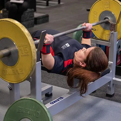 Olivia Broome laying on a bench lifting weights