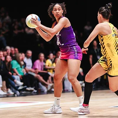 Rhea Dixon holding a netball during a match