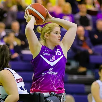 Robyn Love during a wheelchair basketball match holding the ball in the air