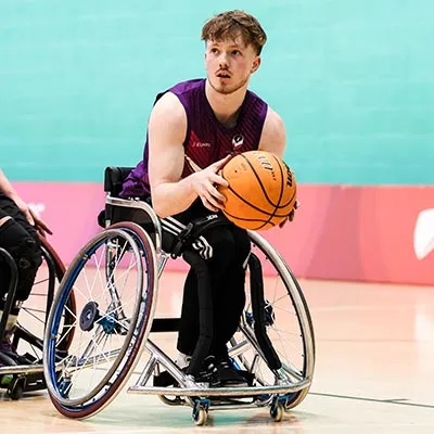 Thomas Harvey holding a basketball during a wheelchair basketball match