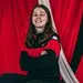 Tegan Hargreaves wearing a red and black top stood in front of a red background