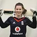 Tammy Beaumont wearing a black top with a large Vodafone logo and holding a cricket bat across her shoulders