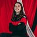 Tegan Hargreaves wearing a red and black top stood in front of a red background