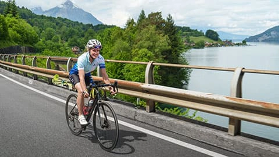 Fay Manner riding a bike on a bridge in her “ride to steep lines” project