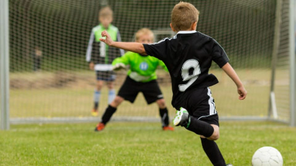 A young person kicking a ball