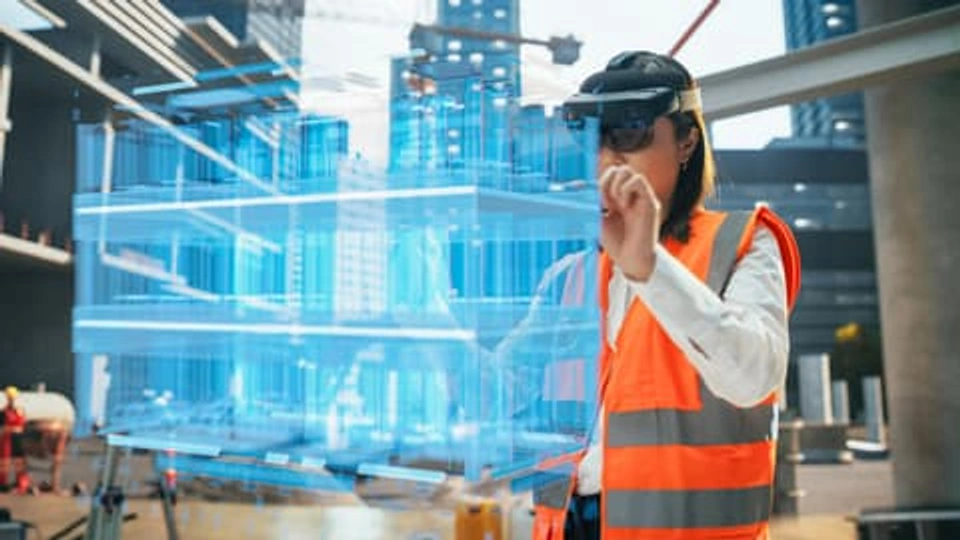 A female construction worker examines digital plans.