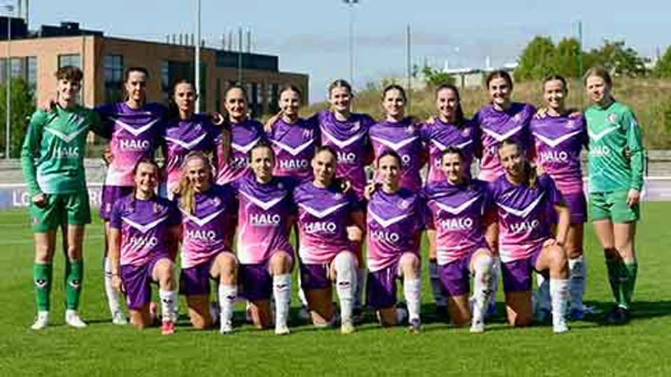 Lightning Football squad wearing kit, stood for a team photo on a football pitch.