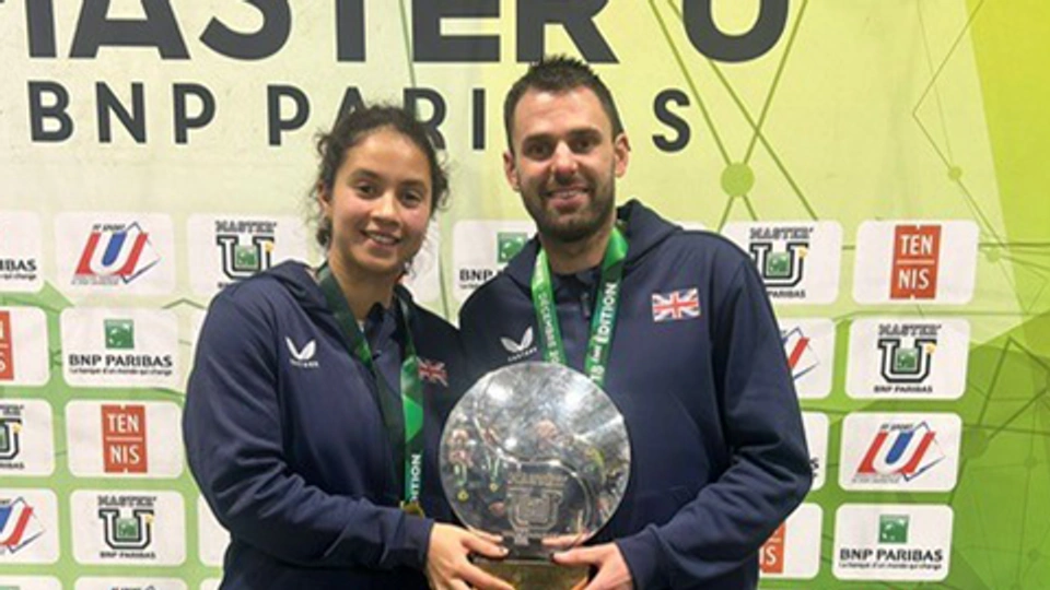 eliz maloney and tom kisiel holding the championship trophy