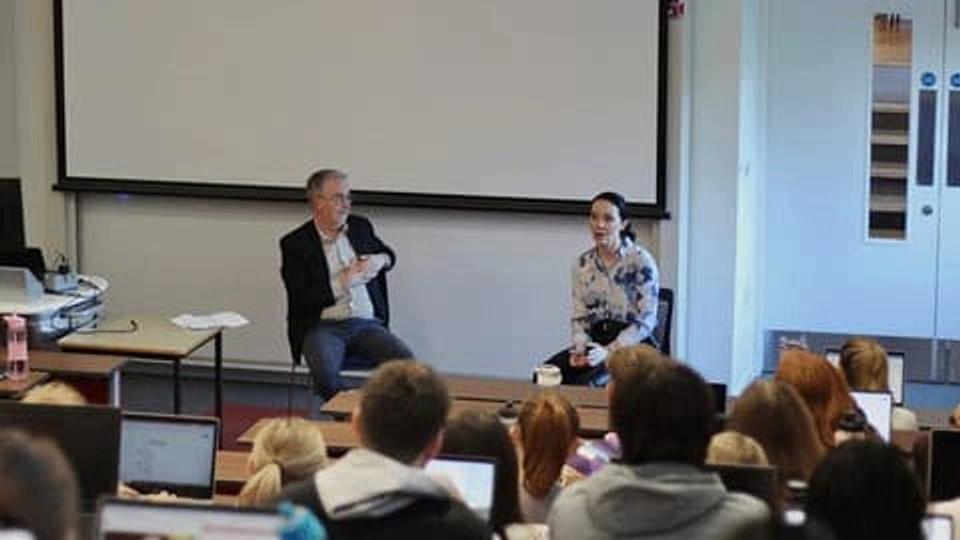 a male and female talking to a group of students in a lecture theatre