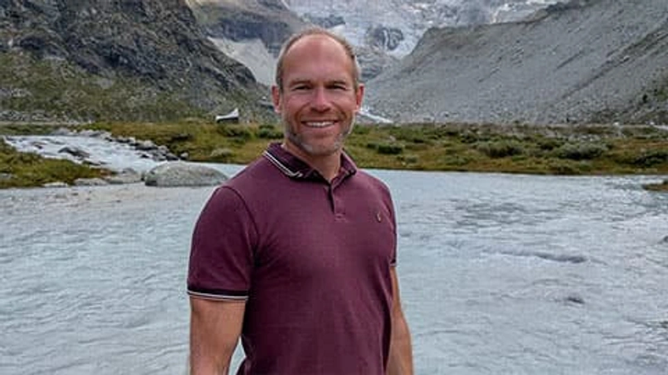 Peter Kraftl in a landscape with mountains and a river