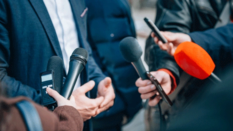 microphones being held for politicans to speak