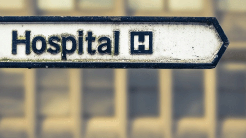 an old sign directing to a hospital