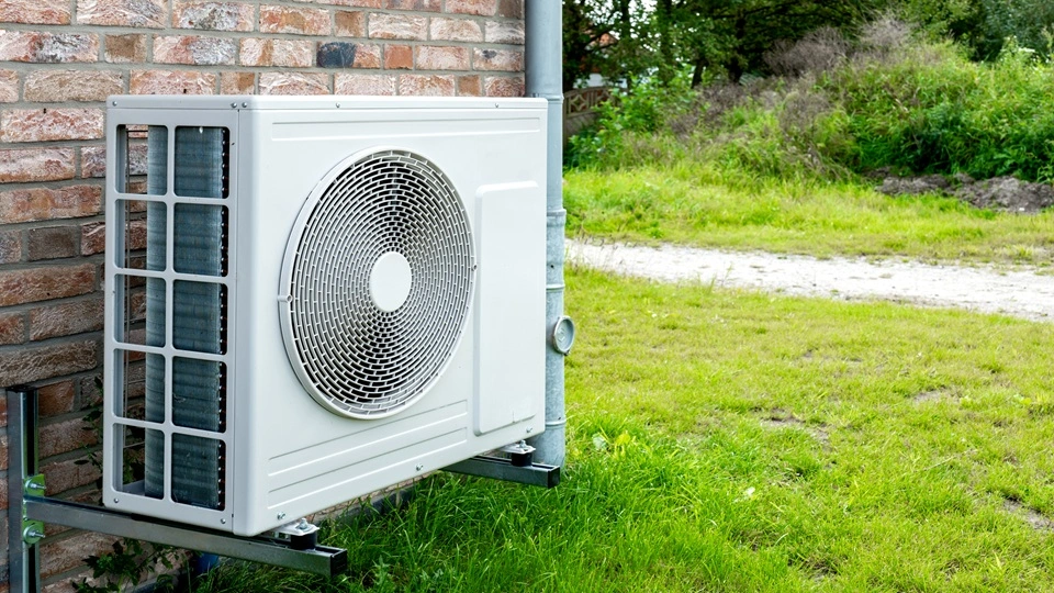 A heat pump attached to the side of a house.