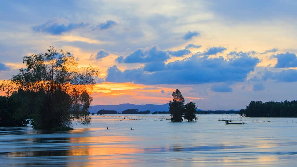 Tonle Sap Lake in Cambodia at sunset, showing the sun setting over a large body of water