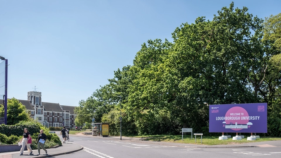 The entrance to the campus with green trees and signage saying 'Welcome to Loughborough University'