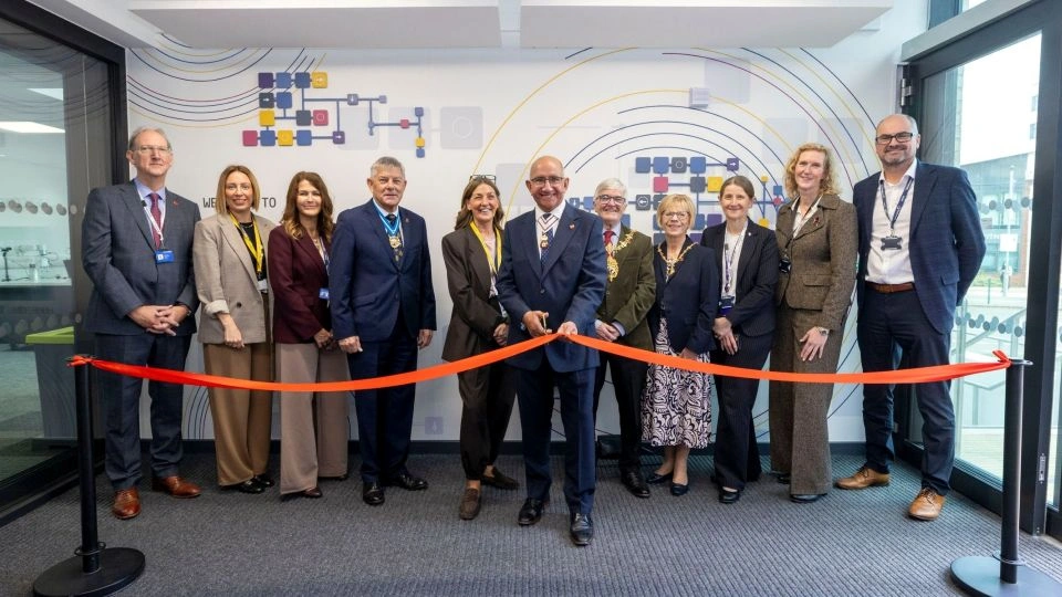 A group of people stand togther for the ribbon cutting ceremony, marking the opening of the new East Midlands Institute  of Technology facility