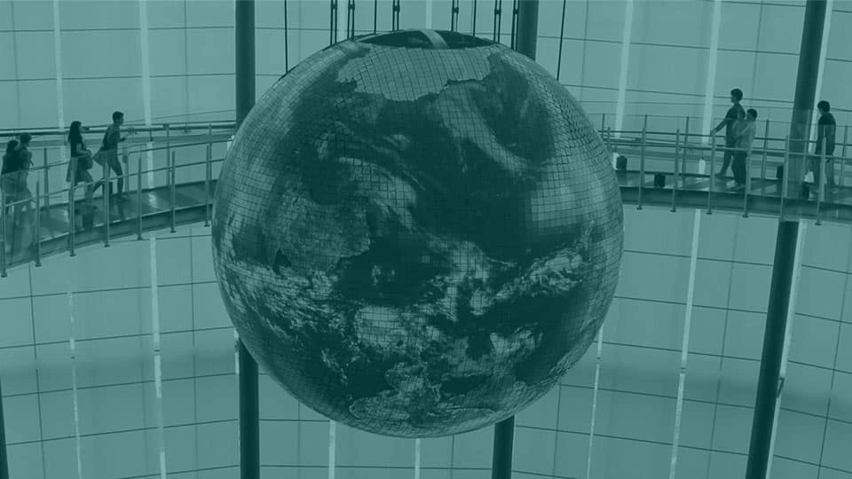 A graphic of a globe with people walking around it