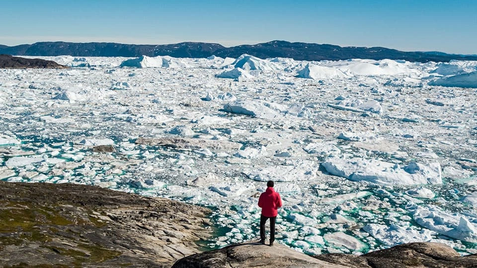 A man standing on a melting glacier