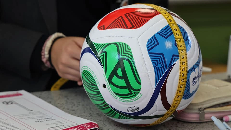 A football used in the World Cup being measured using a yellow measuring tape