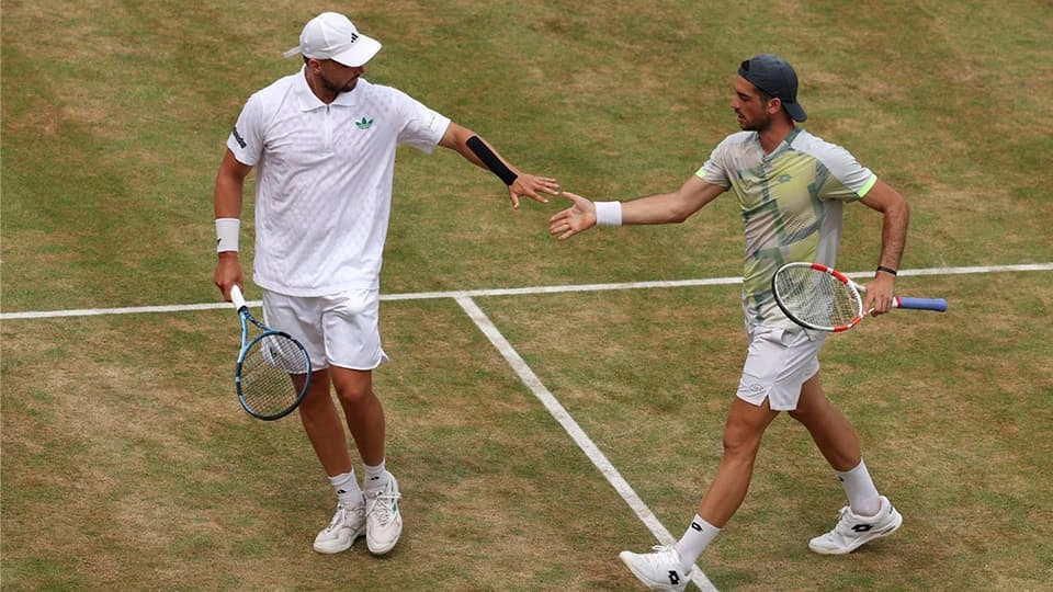 Lloyd Glasspool and Julian Cash touching hands on a tennis court