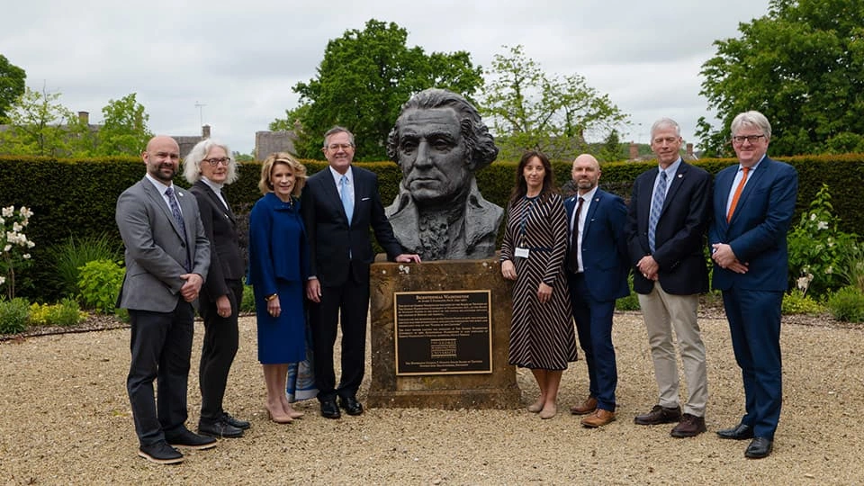 Sam Edwards standing with a group of people around the statue of George Washington