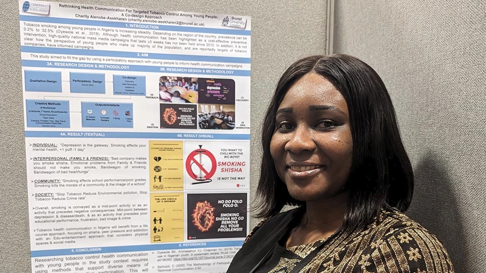 Charity Aienobe-Asekharen stands in front of a poster explaining her prize winning project to reduce tobacco use in young Nigerians
