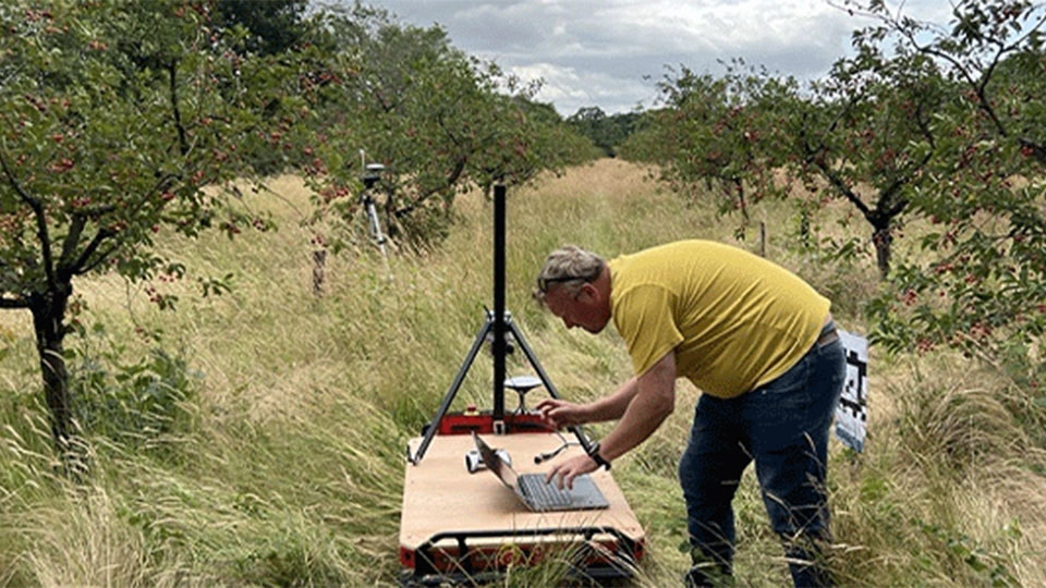 Man in field with autonomous system