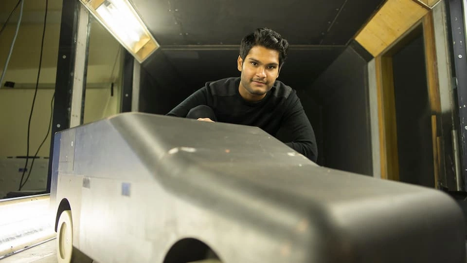 Student in wind tunnel with car