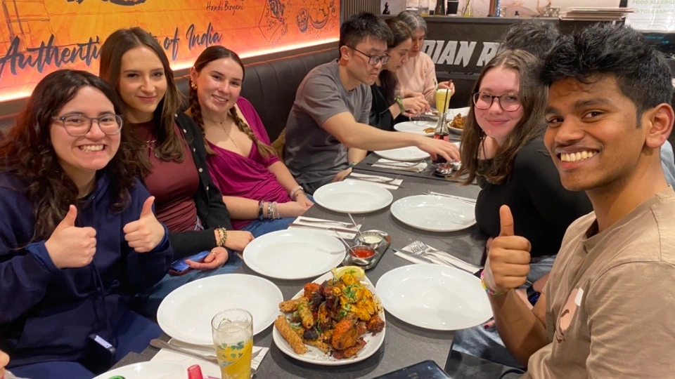 A group of friends eating in an euthentic Indian restaurant.