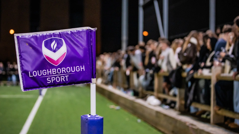 a corner flag with a blurred crowd in the background