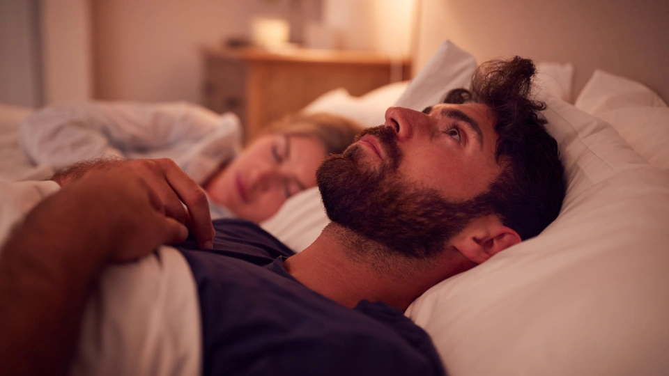 a man lying awake in bed