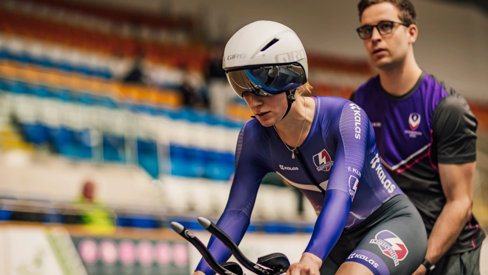 a woman on a bike in a velodrome
