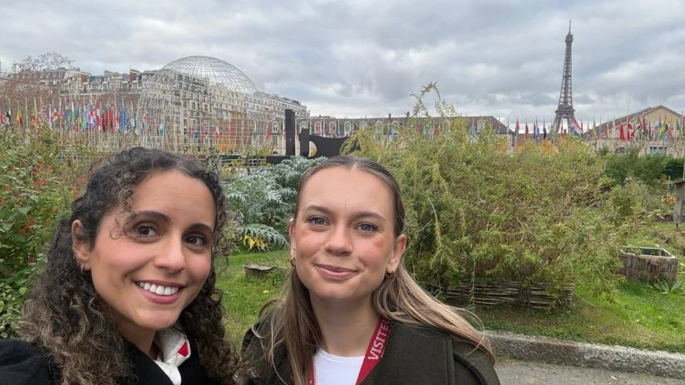 two people pose outside the Eiffel tower in paris