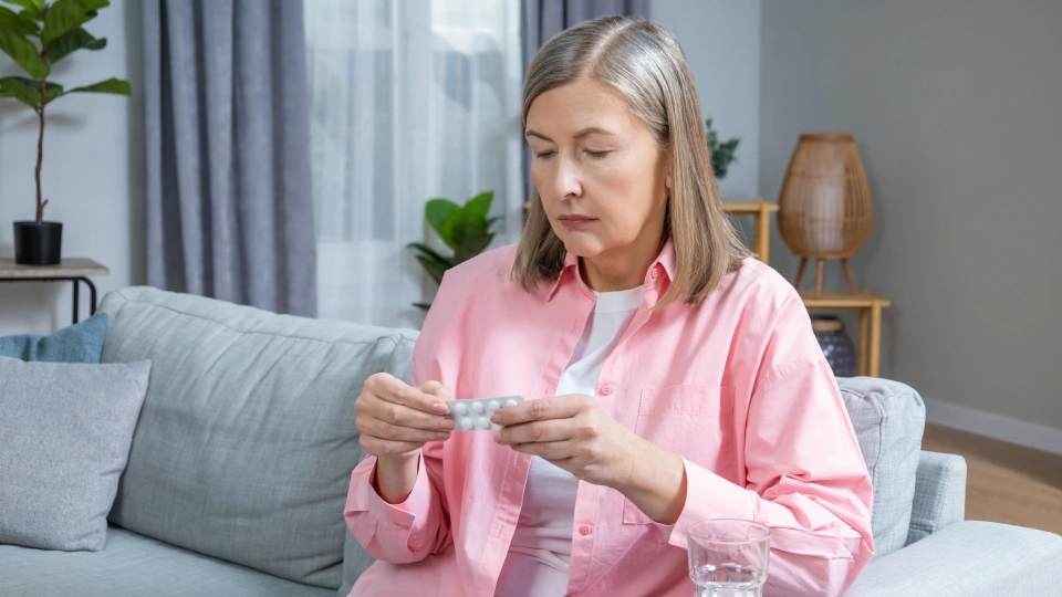 a woman looking a pill packet