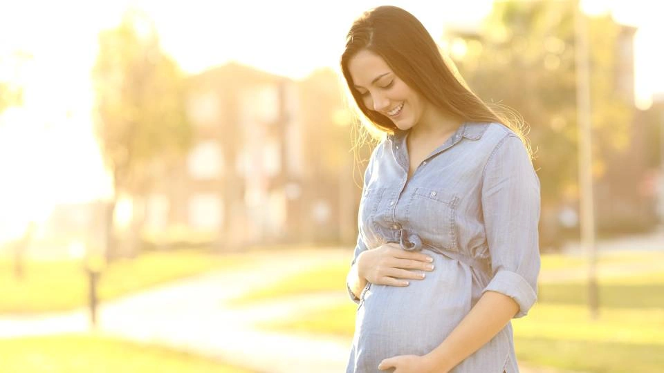 a pregnant woman holds her stomach
