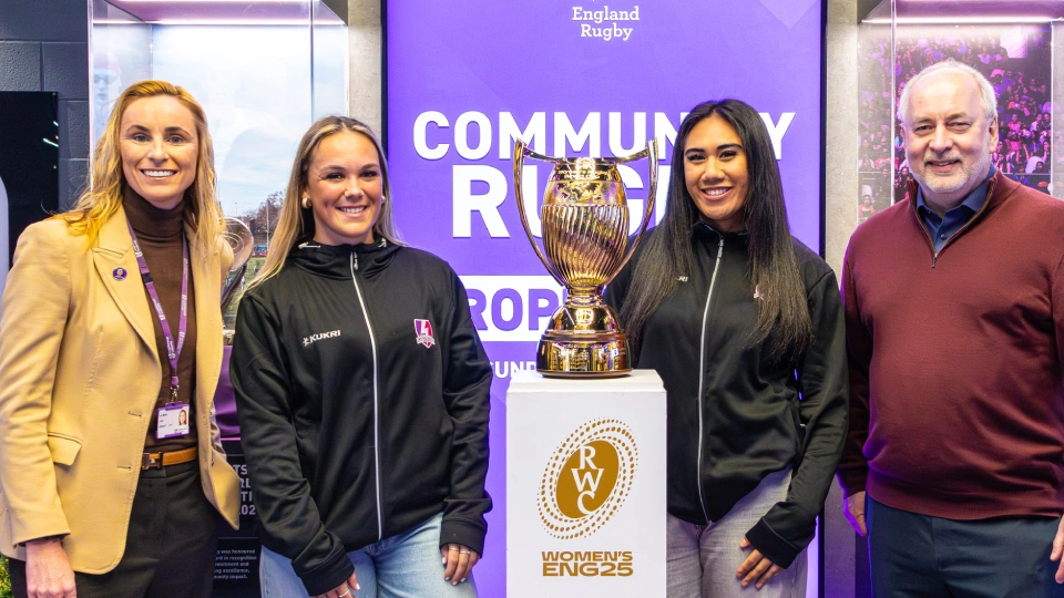 people pose next to the rugby world cup trophy 2025