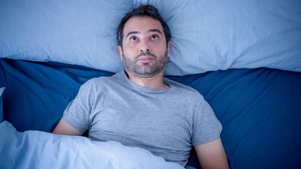 a man lying awake in bed