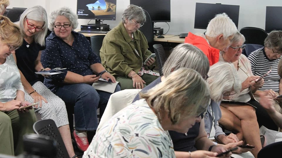 Women's Institute members sat at desks using phones
